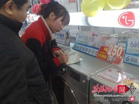 家電賣場工作人員幫顧客填寫“家電以舊換新”的單子