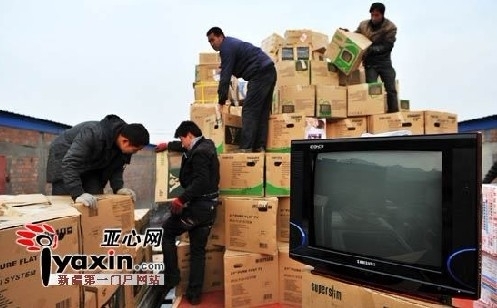 四五名工作人員正在從一輛重型貨車上搬運(yùn)已被查扣的電視機(jī)。