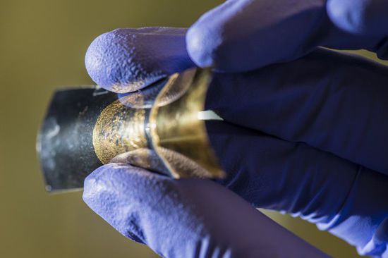 A thin-film energy storage device, seen attached to a polymer backing, retains its battery...