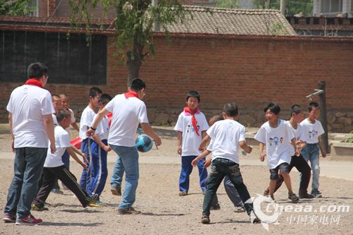 “红顶奖”组委会成员与张家口赤城县茨营子小学的孩子们一起踢足球（图）